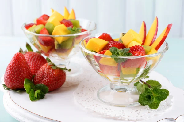 Insalata di frutta con menta in bicchieri su tavola di legno e tavole di sfondo — Foto Stock
