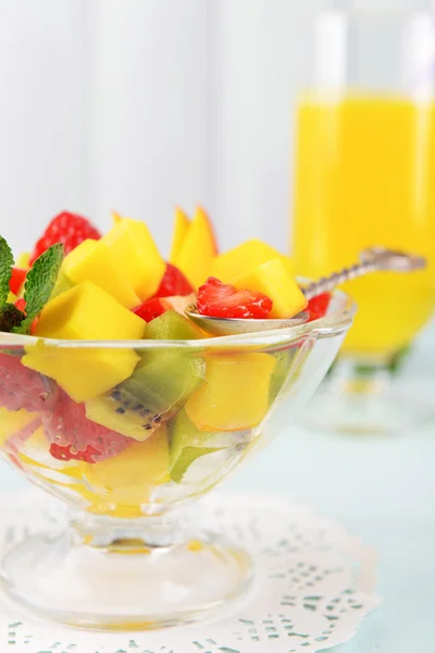 Fruktsallad i glasskål med mynta och apelsinjuice på färg trä bakgrund — Stockfoto