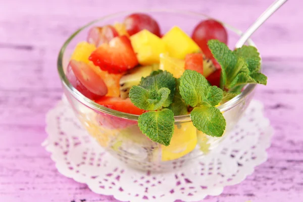 Obstsalat mit Minze im Glas auf farbigem Holzhintergrund — Stockfoto