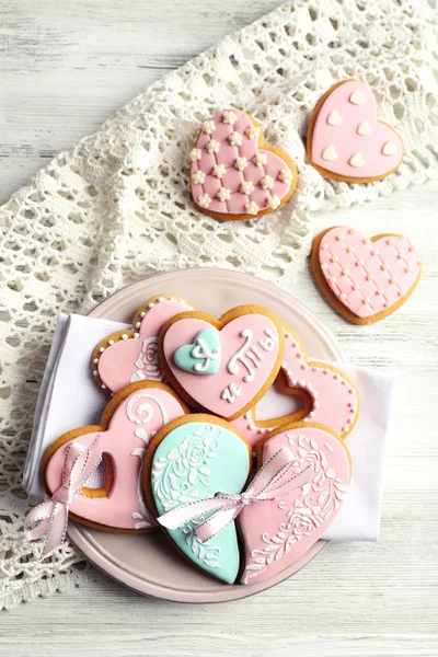 Herzförmige Plätzchen zum Valentinstag auf Teller, auf farbigem Holzhintergrund — Stockfoto