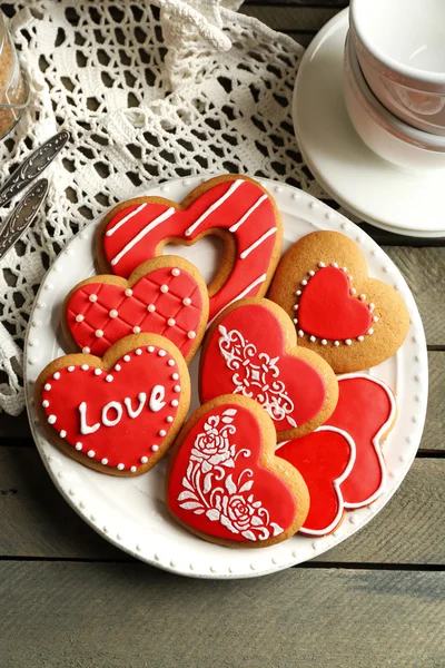 Galletas en forma de corazón para el día de San Valentín en servilleta, sobre fondo de madera de color — Foto de Stock