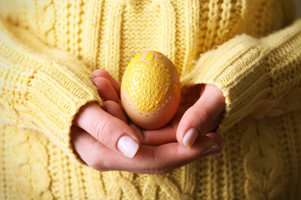 Mãos femininas segurando ovo de Páscoa, vista close-up — Fotografia de Stock
