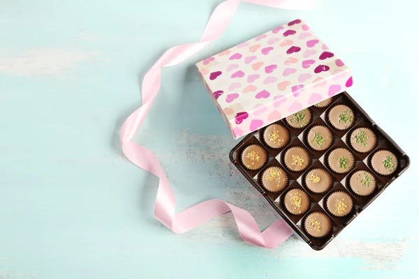Coffret cadeau avec de savoureux bonbons au chocolat sur table en bois — Photo