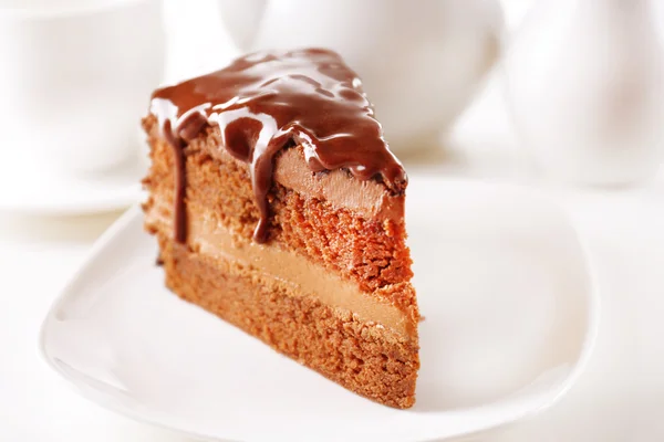 Delicious chocolate cake on plate on table on light background — Stok Foto