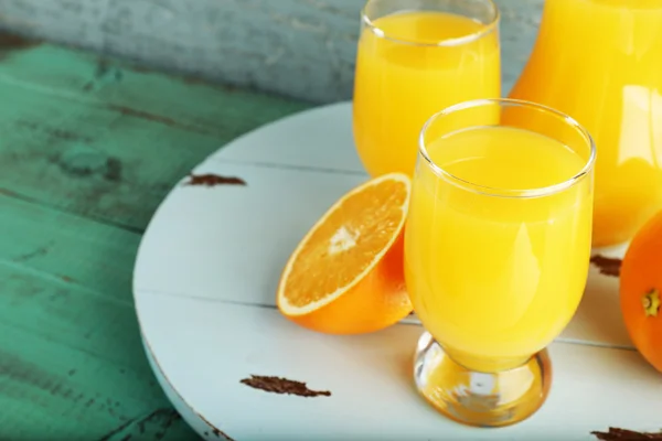 Bicchiere di succo d'arancia con fette su sfondo di legno a colori — Foto Stock