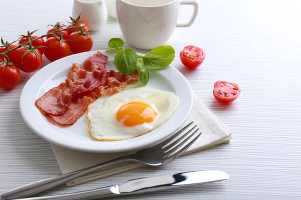 Bacon et oeufs sur fond de table en bois couleur — Photo