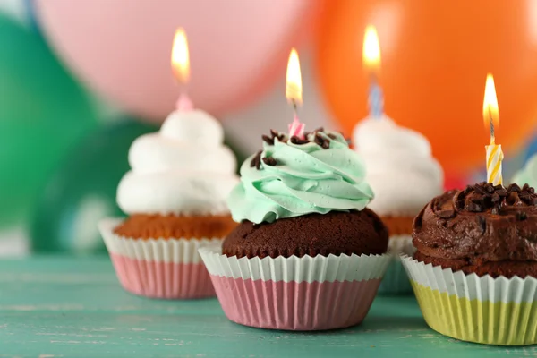 Deliciosos cupcakes de cumpleaños en la mesa sobre un fondo brillante —  Fotos de Stock