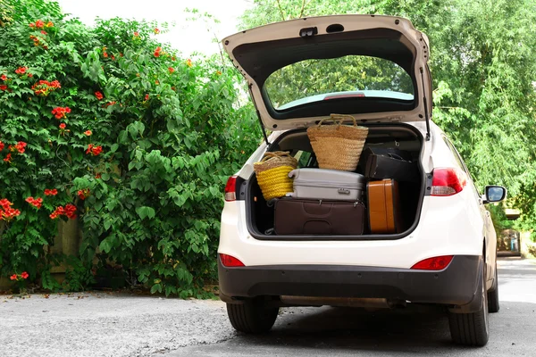 Maletas y bolsas en maletero de coche listas para salir de vacaciones — Foto de Stock