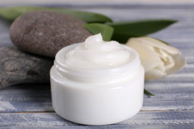 Spa taş ve ahşap zemin üzerine lale ile kozmetik krem