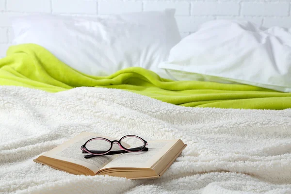 Buch und Brille im Bett in Großaufnahme — Stockfoto