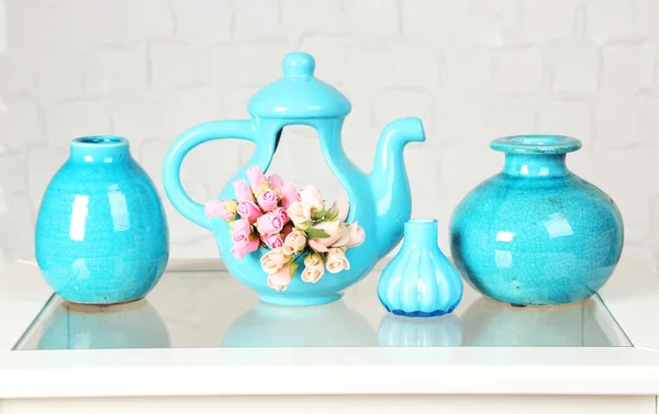 Interior com vasos decorativos e pequenas rosas na parte superior da mesa e fundo de parede de tijolo branco — Fotografia de Stock