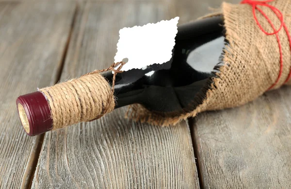 Botella de vino tinto envuelta en tela de arpillera —  Fotos de Stock