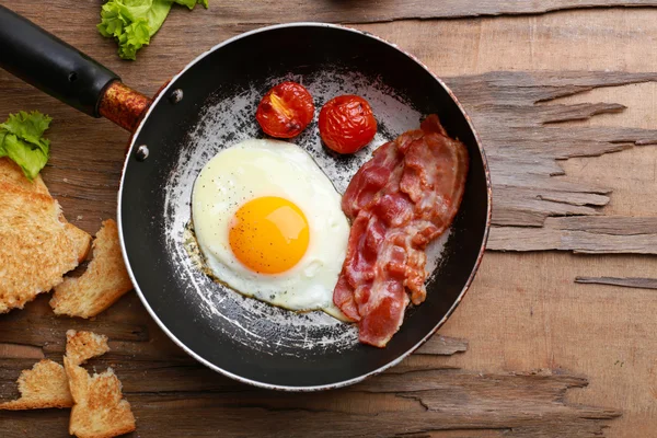Bacon and eggs on wooden planks — Stock Photo, Image