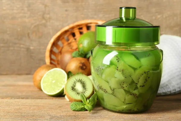 Smakelijke kiwi jam in glazen pot op houten achtergrond — Stockfoto