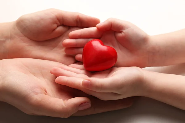 Corazón en manos de niño y madre aisladas en blanco — Foto de Stock