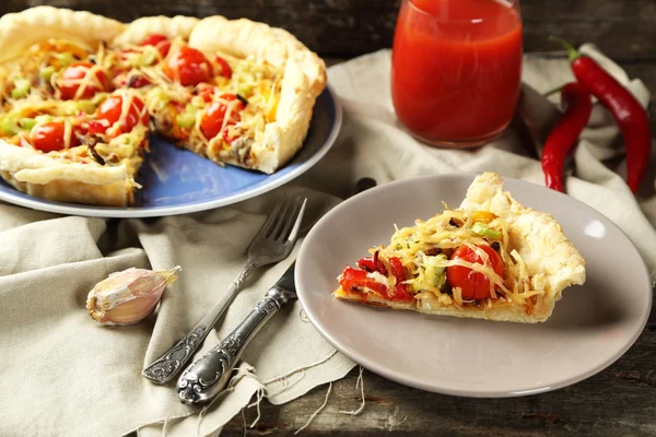 Torta de legumes com páprica, tomate e queijo no prato, no fundo de madeira — Fotografia de Stock