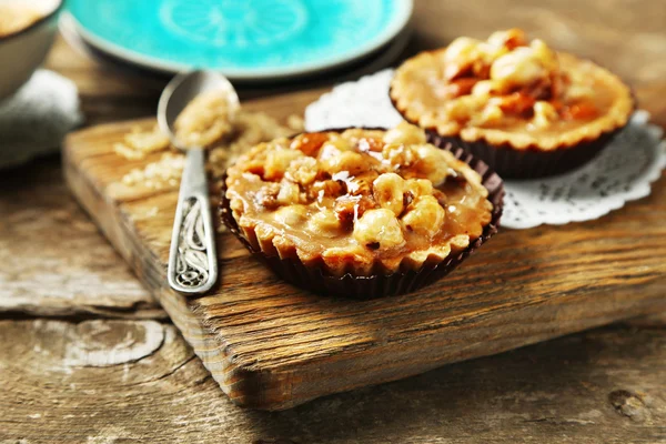 Mini pasteles con tuercas sobre fondo de madera — Foto de Stock