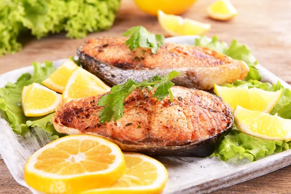 Sabroso pescado al horno en el plato en primer plano de la mesa — Foto de Stock