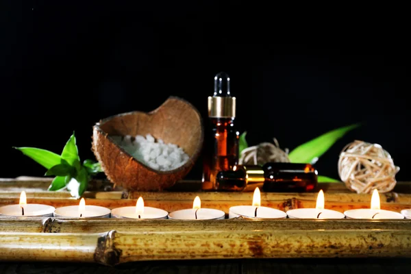 Piękna kompozycja z olejków aromatycznych i świece na stole na ciemnym tle — Zdjęcie stockowe