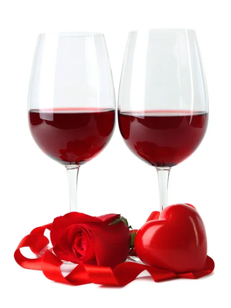 Composición con vino tinto en copas, rosa roja, cinta y corazones decorativos aislados en blanco — Foto de Stock