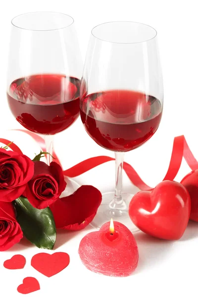 Composición con vino tinto en copas, rosas rojas, cinta y corazones decorativos sobre fondo claro —  Fotos de Stock