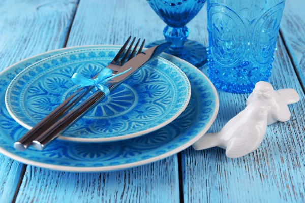 Prázdný barevný talíř, sklenice a příbory na dřevěném stole — Stock fotografie