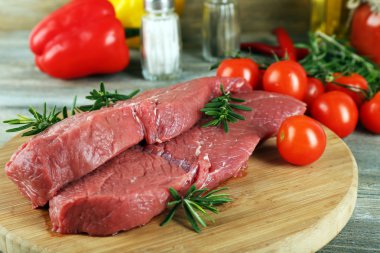 Kesme tahtası sebze ve baharat ahşap arka plan üzerinde ham sığır eti biftek