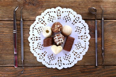 Diş hekimi araçları Dantelli peçete ahşap arka plan üzerinde sweets ile