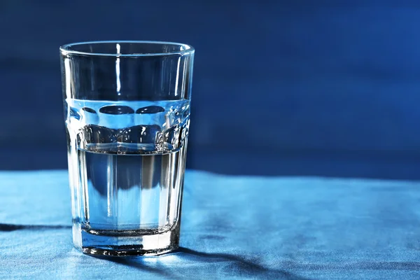 Glas Wasser auf dem Tisch auf Holzgrund — Stockfoto