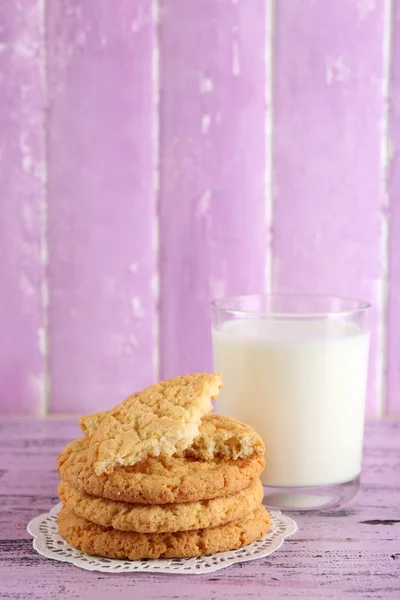 美味饼干和牛奶色木背景上的玻璃 — 图库照片