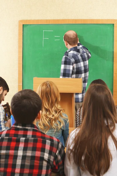 Grupo de estudiantes sentados en el aula y profesores oyentes —  Fotos de Stock