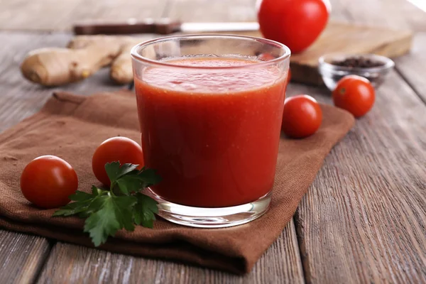 Verre de jus de tomate aux tomates cerises sur table en bois close up — Photo