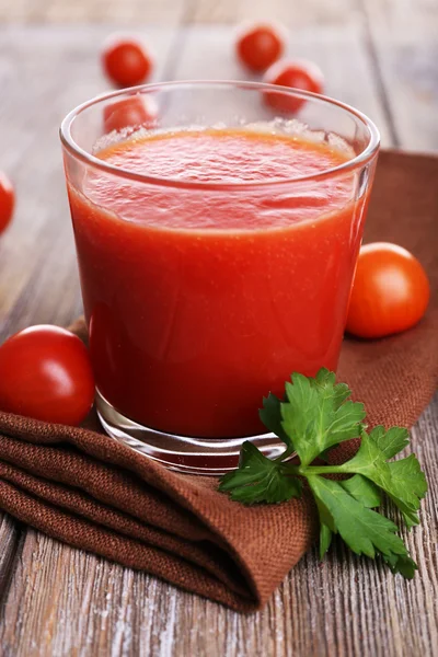 Bicchiere di succo di pomodoro con pomodorini su tavolo di legno da vicino — Foto Stock