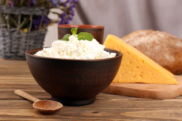 Tasty dairy products with bread and dry flowers on table close up — Stock Photo, Image