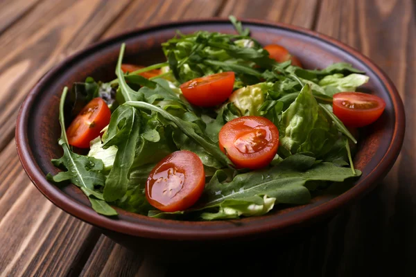 Roka ve ahşap masa üzerinde domates salatası — Stok fotoğraf