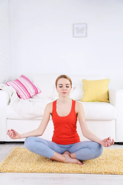 Young woman doing yoga at home — Stock Photo, Image