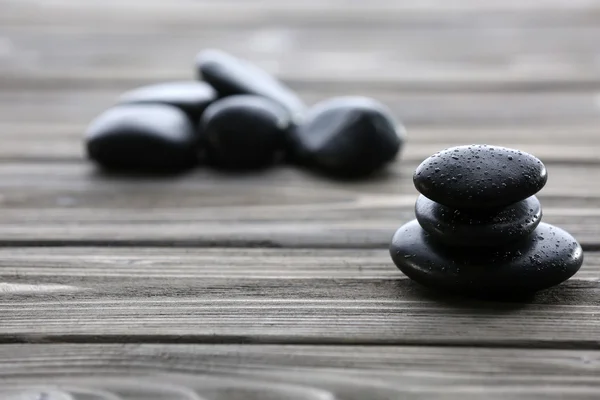 Pedras de spa com gotas de água no fundo de madeira — Fotografia de Stock