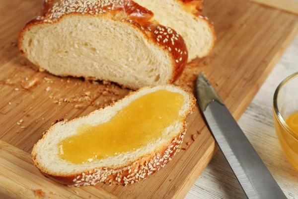 Pão fresco fatiado com mel na tábua de corte na mesa de madeira close up — Fotografia de Stock