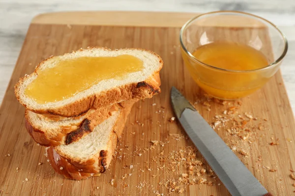 Panino fresco affettato con miele sul tagliere sul tavolo di legno da vicino — Foto Stock