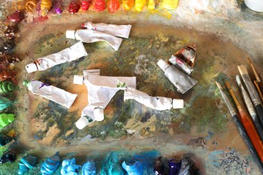 Akrilik boya boya tüpleri ve ahşap palet üzerinde fırçalar ile