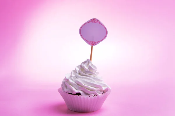 Delicious cupcake with inscription on table on pink background — Stock Photo, Image
