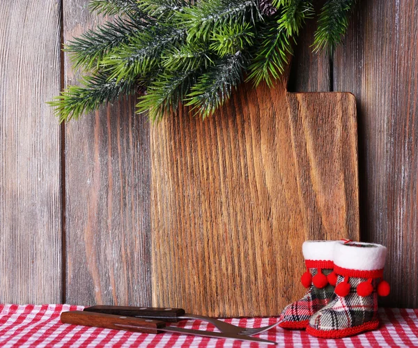 Cutting board with Christmas decoration on wooden planks background — Stock Photo, Image