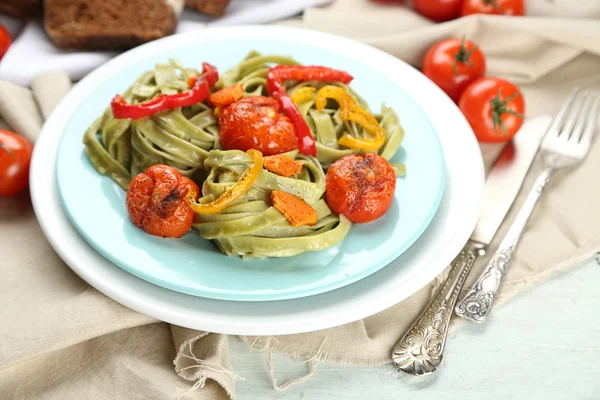 Pâtes savoureuses au poivre, carotte et tomates sur fond de table en bois — Photo