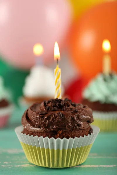 Deliciosos cupcakes de cumpleaños en la mesa sobre un fondo brillante — Foto de Stock