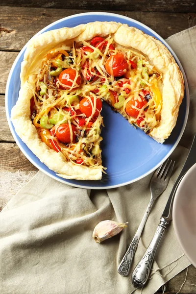 Torta de legumes com páprica, tomate e queijo no prato, no fundo de madeira — Fotografia de Stock