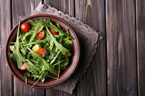 Roka ve ahşap masa üzerinde domates salatası — Stok fotoğraf