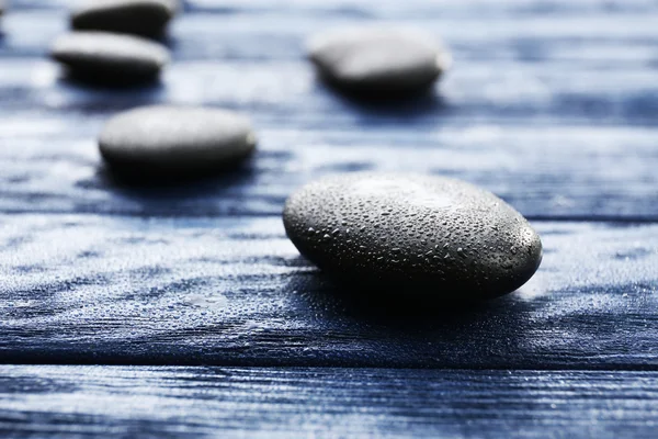 Spa stones with water drops on wooden background — Stock Photo, Image