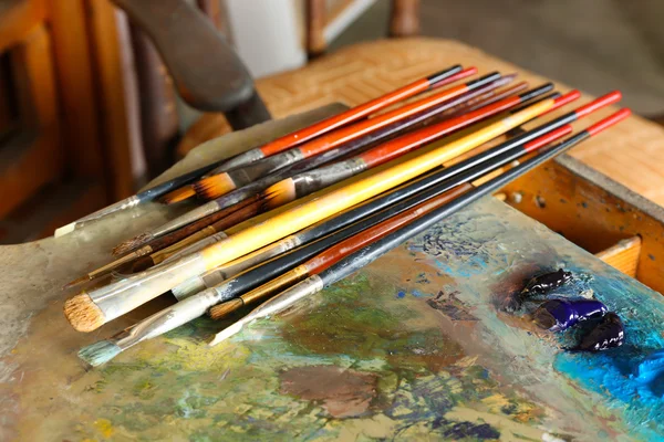 Vernice acrilica con pennelli su tavolozza di legno — Foto Stock