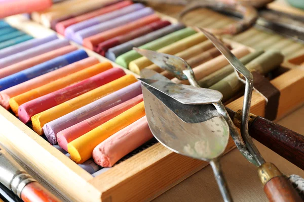 Colorful chalk pastels in box with palette knifes close up — Stock Photo, Image