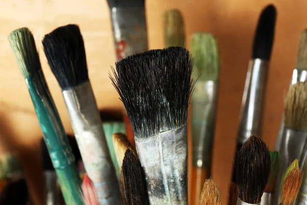 Different paintbrushes on wooden background — Stock Photo, Image